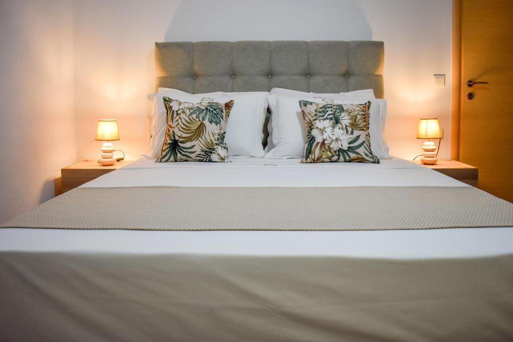 a large white bed with pillows and two lamps at La Maison Plakes 3 BDR Apt in Skiathos