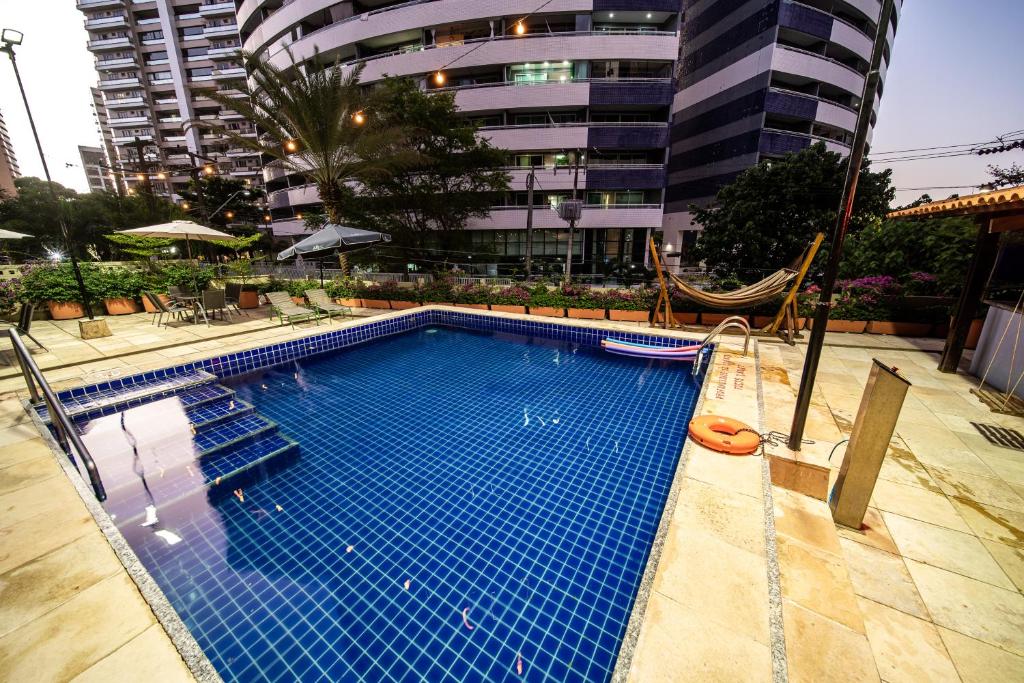 uma grande piscina com rede de descanso em frente a um edifício em ibis Fortaleza Praia de Iracema em Fortaleza