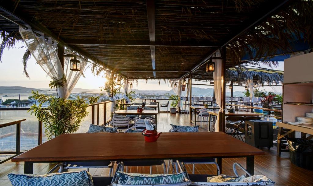 een restaurant met tafels en stoelen en uitzicht op de oceaan bij Hotel Udai Niwas By The Lake in Udaipur