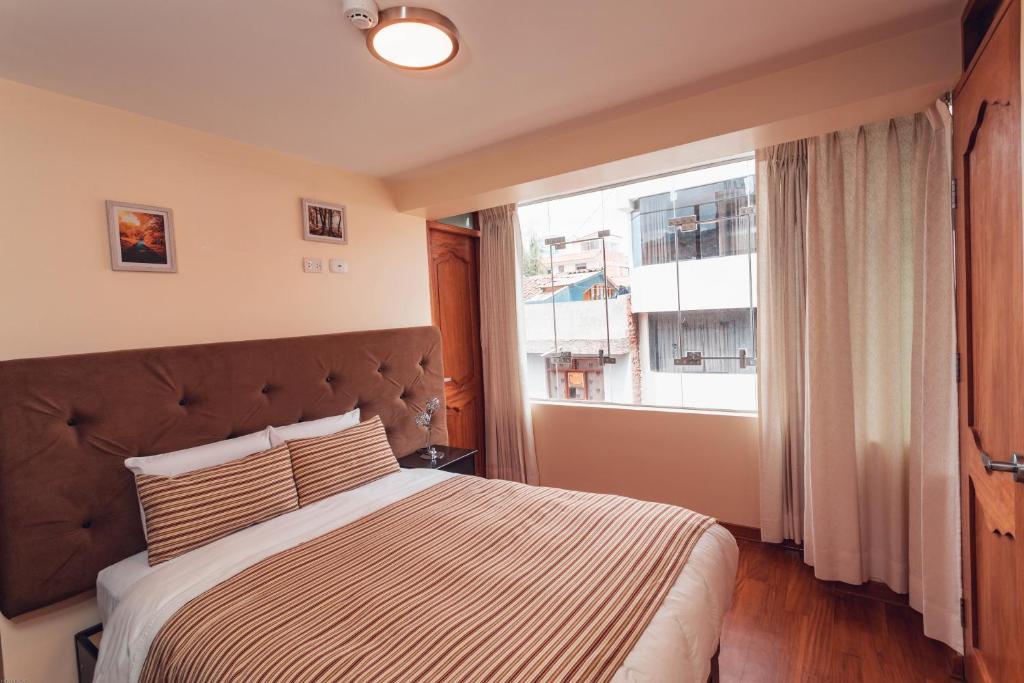 - une chambre avec un grand lit et une fenêtre dans l'établissement Hotel Las Quenas, à Cusco