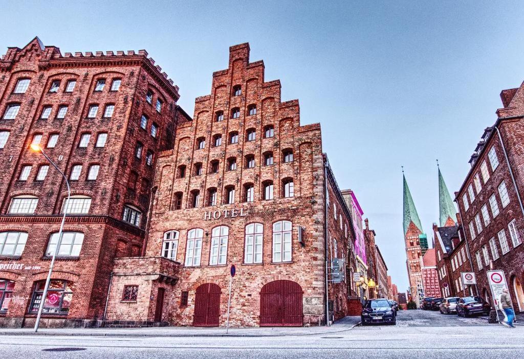 a large brick building on a city street at Hotel Anno 1216 in Lübeck