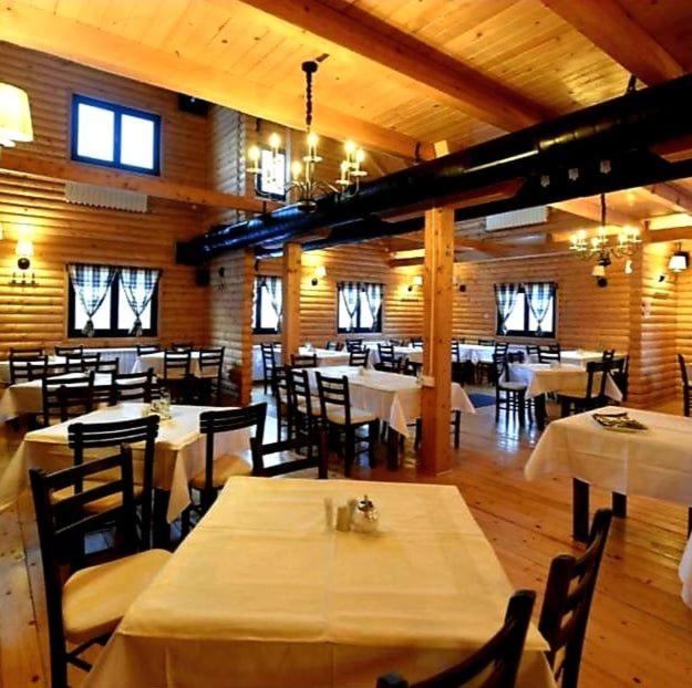 a dining room with tables and chairs in a building at VS Apartman , Hotel Župa Kopaonik in Kopaonik