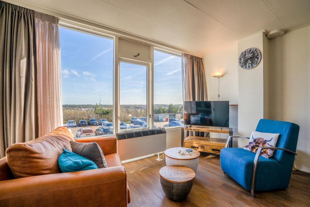 ein Wohnzimmer mit einem Sofa und einem großen Fenster in der Unterkunft Appartementencomplex Juliana 122 in De Koog