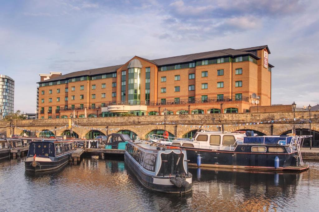 un groupe de bateaux amarrés dans l'eau devant un bâtiment dans l'établissement Best Western Plus The Quays Hotel Sheffield, à Sheffield