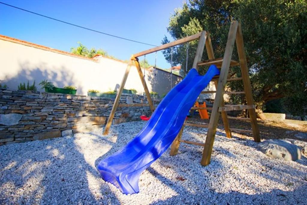 a playground with a blue slide in a yard at Villa Sonnhaus in Marina