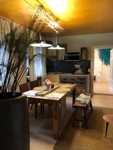 a kitchen with a wooden table and a dining room at Heimat Floral Ferienwohnung in Wadgassen