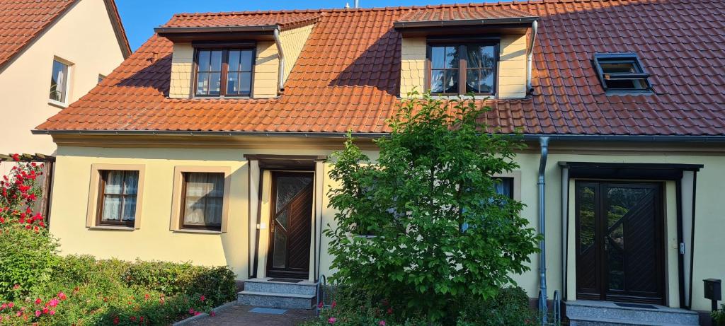 una casa amarilla con techo naranja en Die Ferienwohnung "Am Kietz" en Schwedt