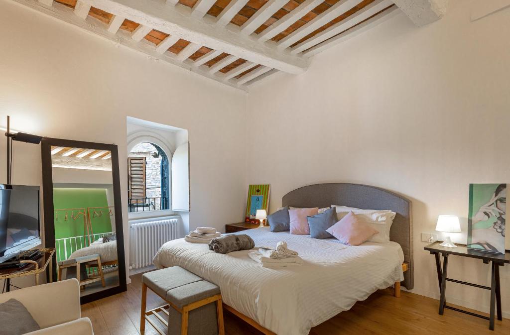 een slaapkamer met een groot bed en een televisie bij Dimora Casina dell'abbondanza in Gubbio