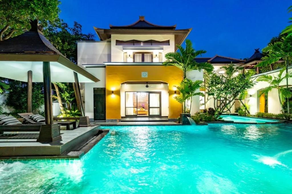 a swimming pool in front of a villa at YiZen Boutique Phutara 5 Bedroom Villa in Nong Prue