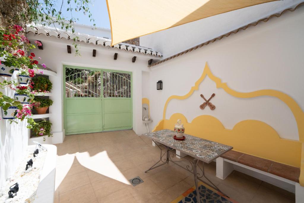 Zimmer mit grüner Tür und Tisch in der Unterkunft Apartamento Andalucía in Cómpeta