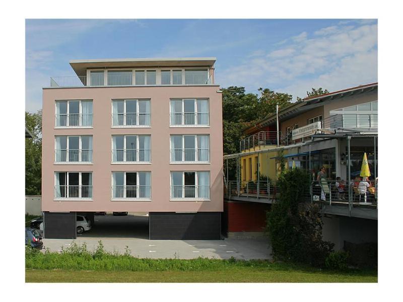 ブライザッハ・アム・ラインにあるVilla Auroraのバルコニーに人々が座っている大きなピンク色の建物