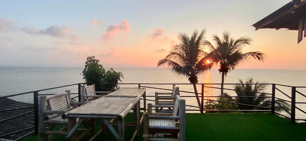 班泰的住宿－帕岸島金灘度假酒店，俯瞰大海的阳台配有一张木桌和椅子
