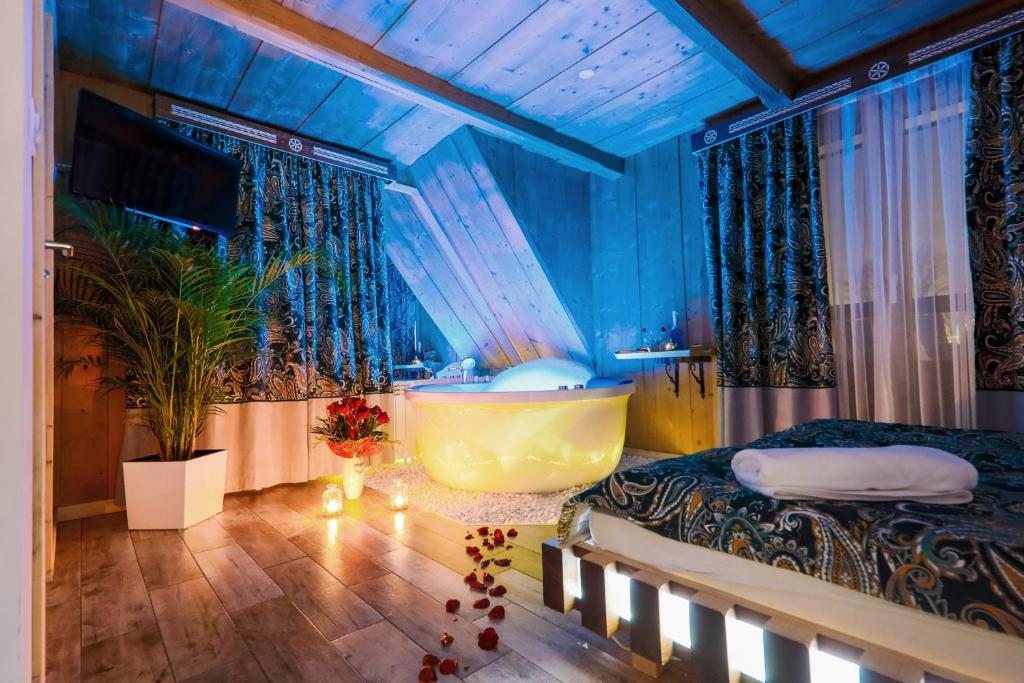 a room with a bed and a bath tub in it at GÓRALSKA VILLA APARTAMENTY Z JACUZZI & HOME SPA & Zakopane in Poronin