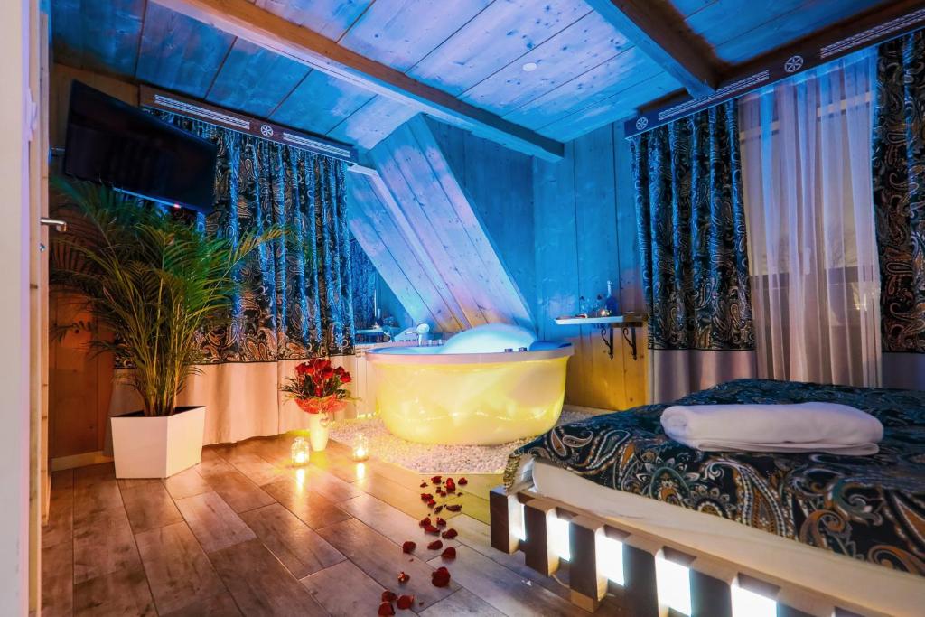 pokój z łóżkiem i wanną w obiekcie GÓRALSKA VILLA APARTAMENTY Z JACUZZI & HOME SPA & Zakopane w Poroninie