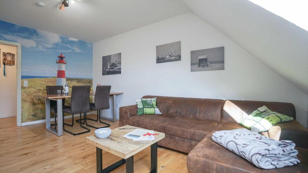 una sala de estar con sofá y un faro pintado en la pared en Ferienwohnungen Hachenberger en Langenhorn