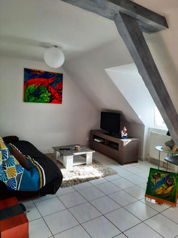 - un salon avec un lit et une télévision dans l'établissement Appartement de 2 chambres avec jardin amenage a Ingersheim, à Ingersheim