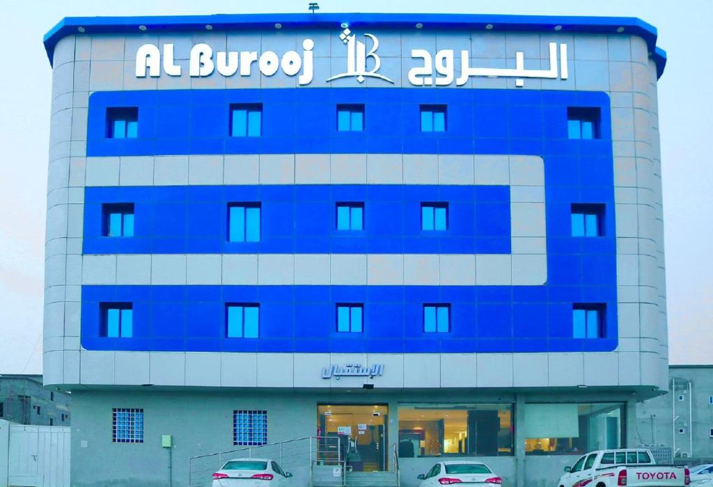 Un bâtiment bleu avec un panneau en haut dans l'établissement فندق البروج, à Jazan