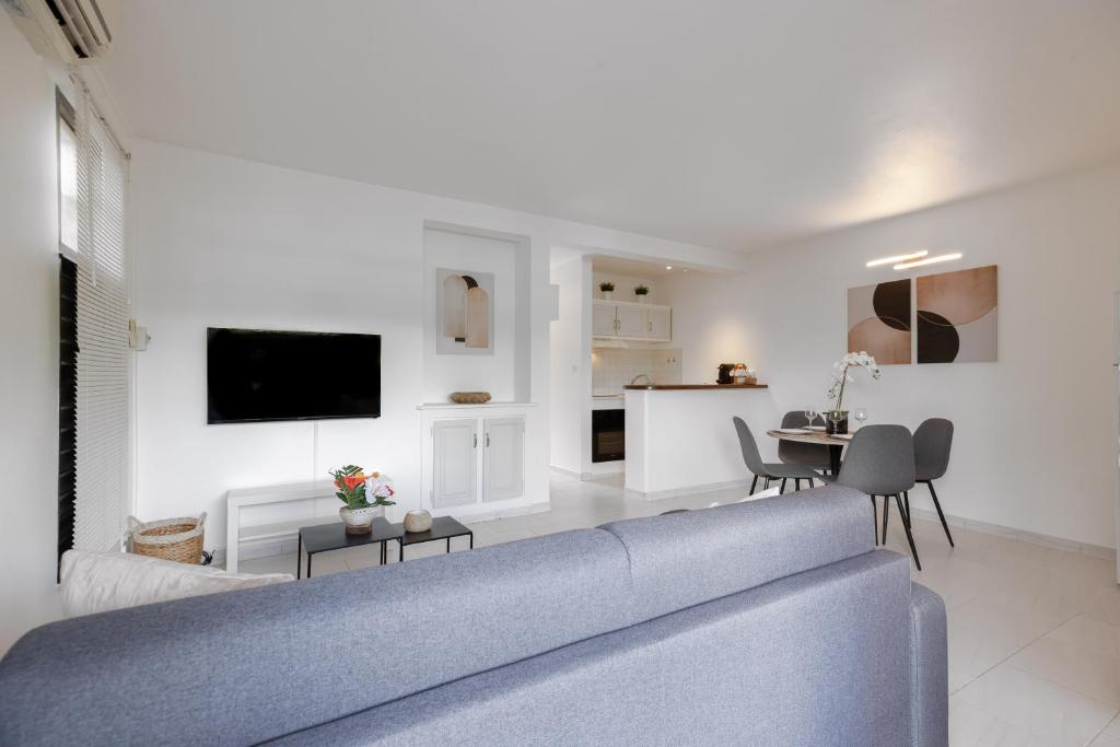 Il comprend un salon avec un canapé bleu et une cuisine. dans l'établissement Eirene - Trois Ilets, à Les Trois-Îlets