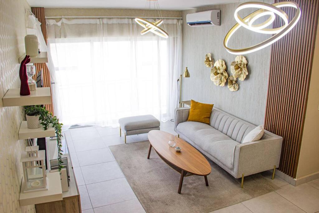 sala de estar con sofá y mesa en Lovely 3-Bedroom Condo with Amazing Rooftop Pool., en Santo Domingo