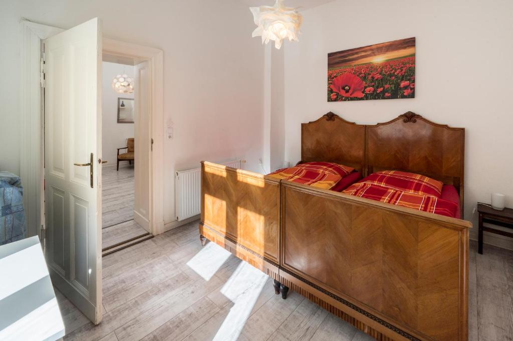 um quarto com uma cama de madeira e lençóis vermelhos em Mehringdamm em Berlim