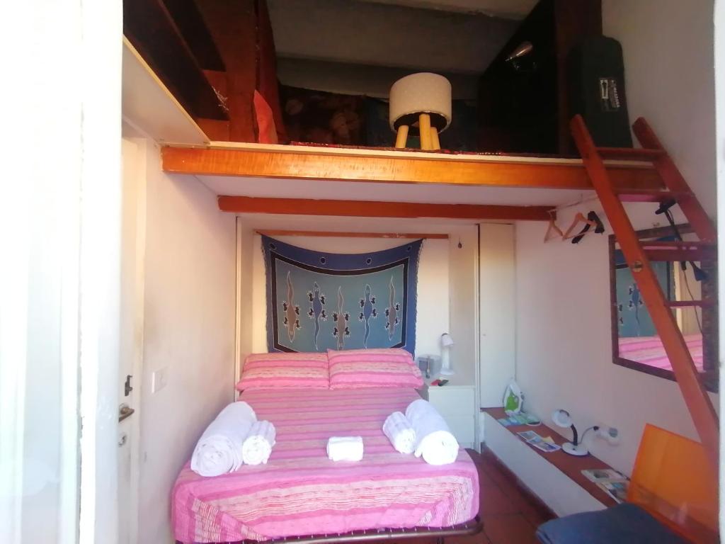 sypialnia z łóżkiem piętrowym i różową narzutą w obiekcie La Tua Casa A Trastevere w Rzymie