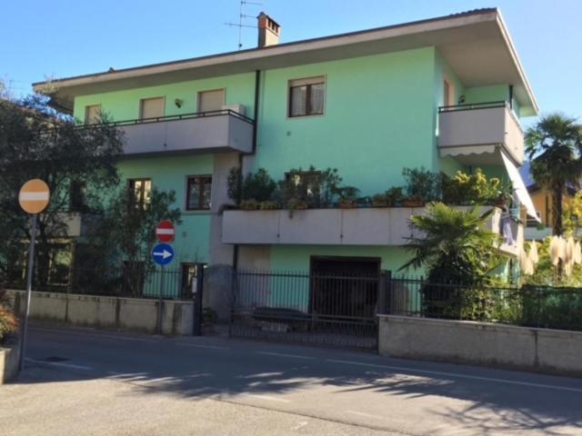 ein grün-weißes Gebäude an der Straßenseite in der Unterkunft Residenza Kob in Arco