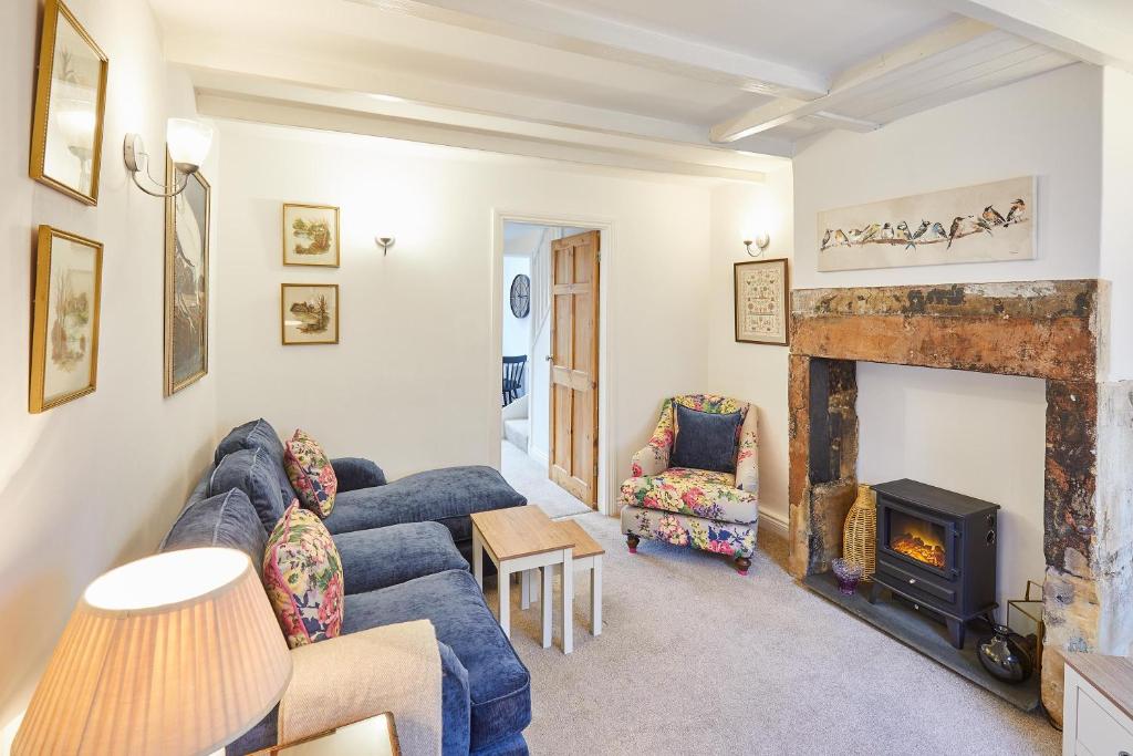a living room with a blue couch and a fireplace at Host & Stay - Waterlily Cottage in Great Ayton