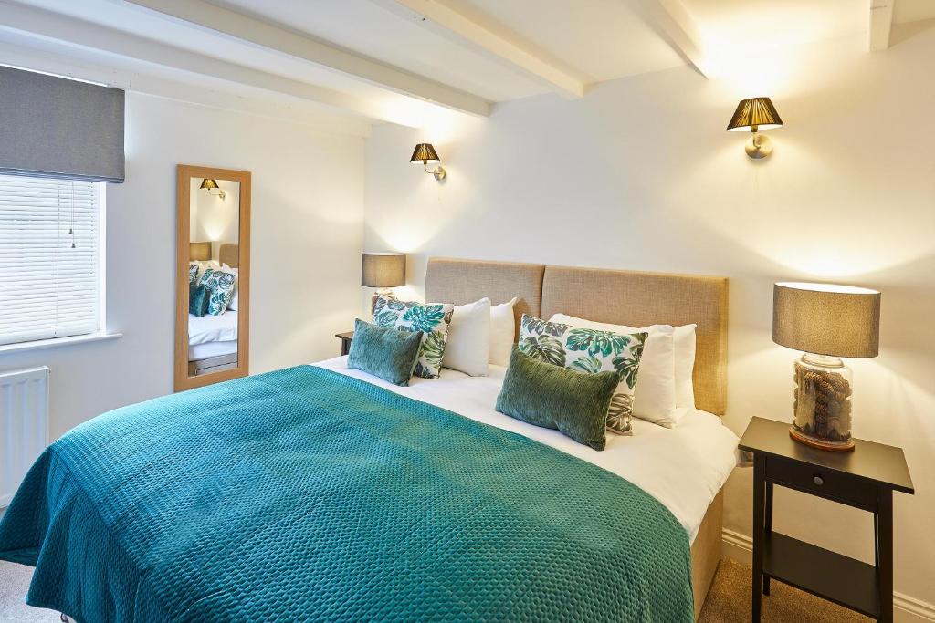 Schlafzimmer mit einem großen Bett mit blauer Decke in der Unterkunft Host & Stay - Waterlily Cottage in Great Ayton