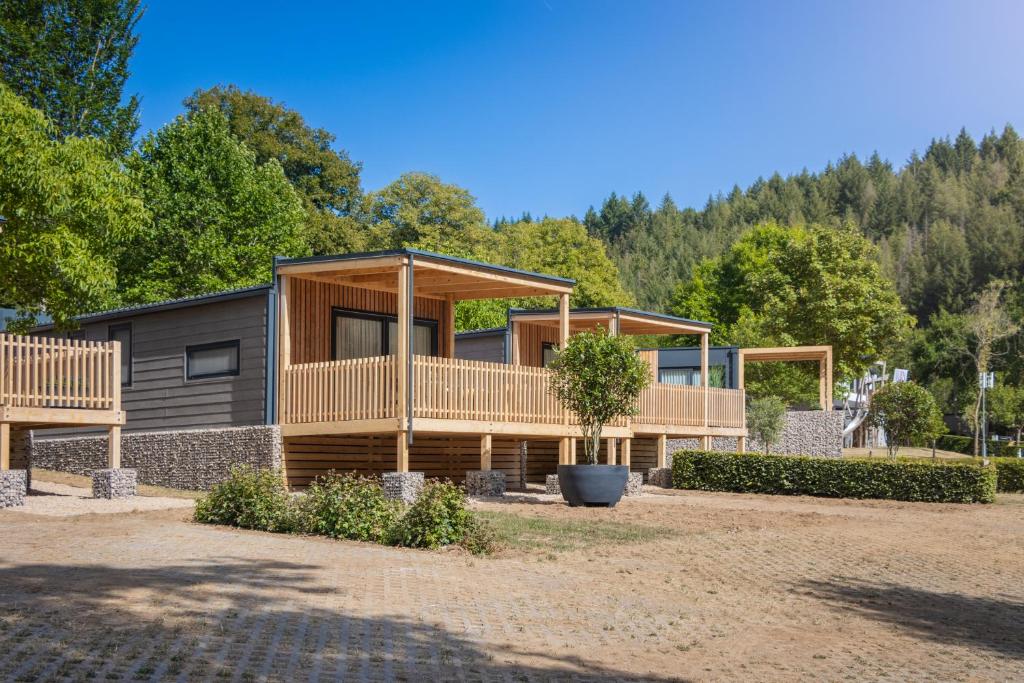 ein modulares Haus mit einer Terrasse und Bäumen in der Unterkunft EuroParcs Kohnenhof in Obereisenbach