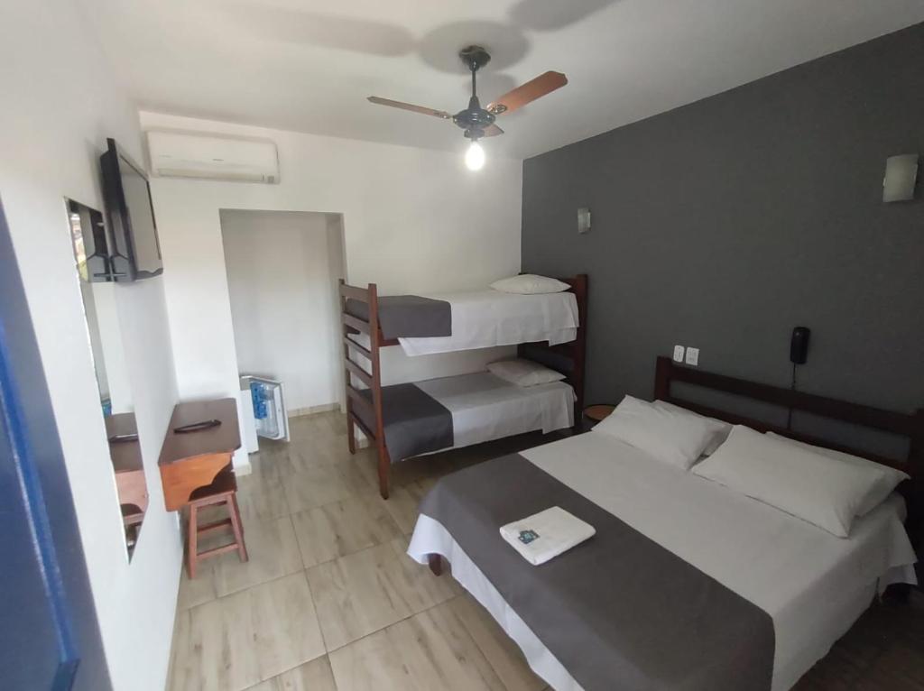 a bedroom with a bed and two bunk beds at Pousada Dona Emilia in Brotas