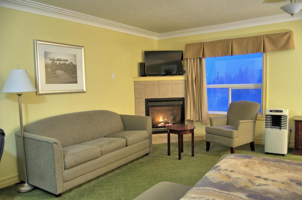 a living room with a couch and a fireplace at Nova Inn Inuvik in Inuvik