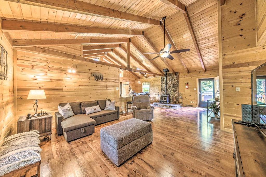 a living room with wooden walls and a ceiling at Updated Ruidoso Cabin with Spacious Deck and View in Ruidoso