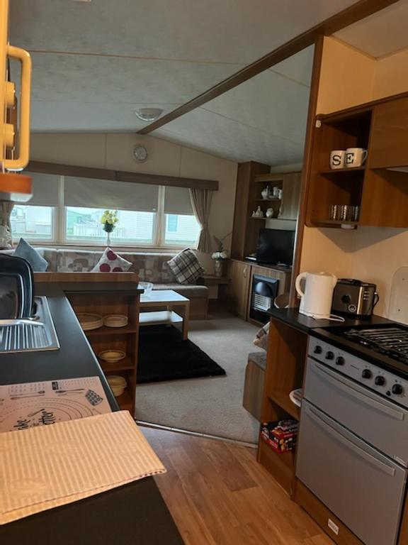 uma cozinha com um fogão e uma sala de estar em Coyles retreat em Stranraer