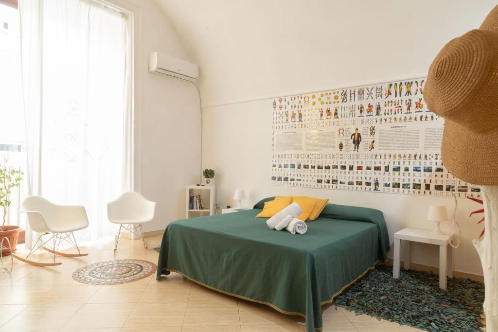 a bedroom with a bed with a green blanket at Totò Style Apartment in Naples