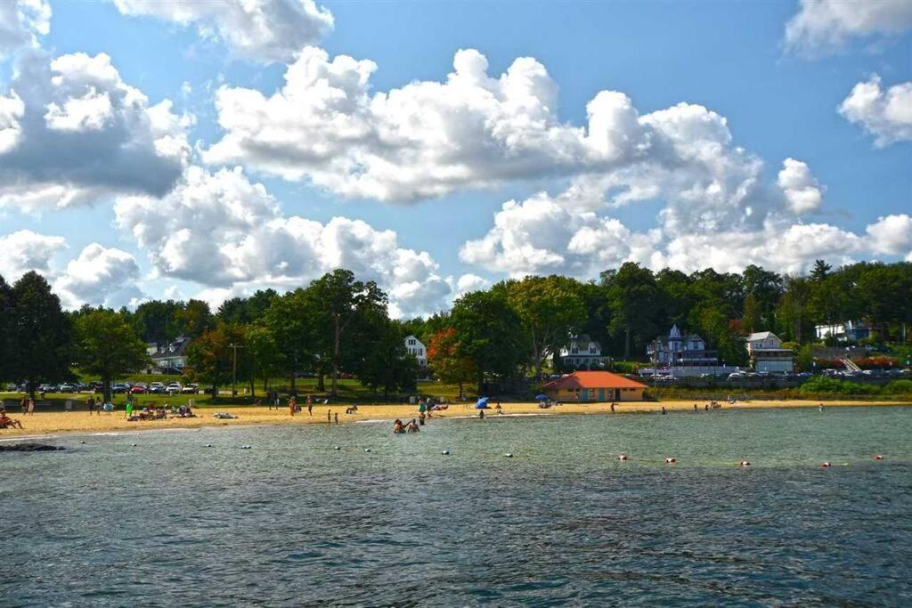 einen Strand mit einer Gruppe von Menschen im Wasser in der Unterkunft 2 Bdrm Condo walking distance to Weirs Beach in Laconia