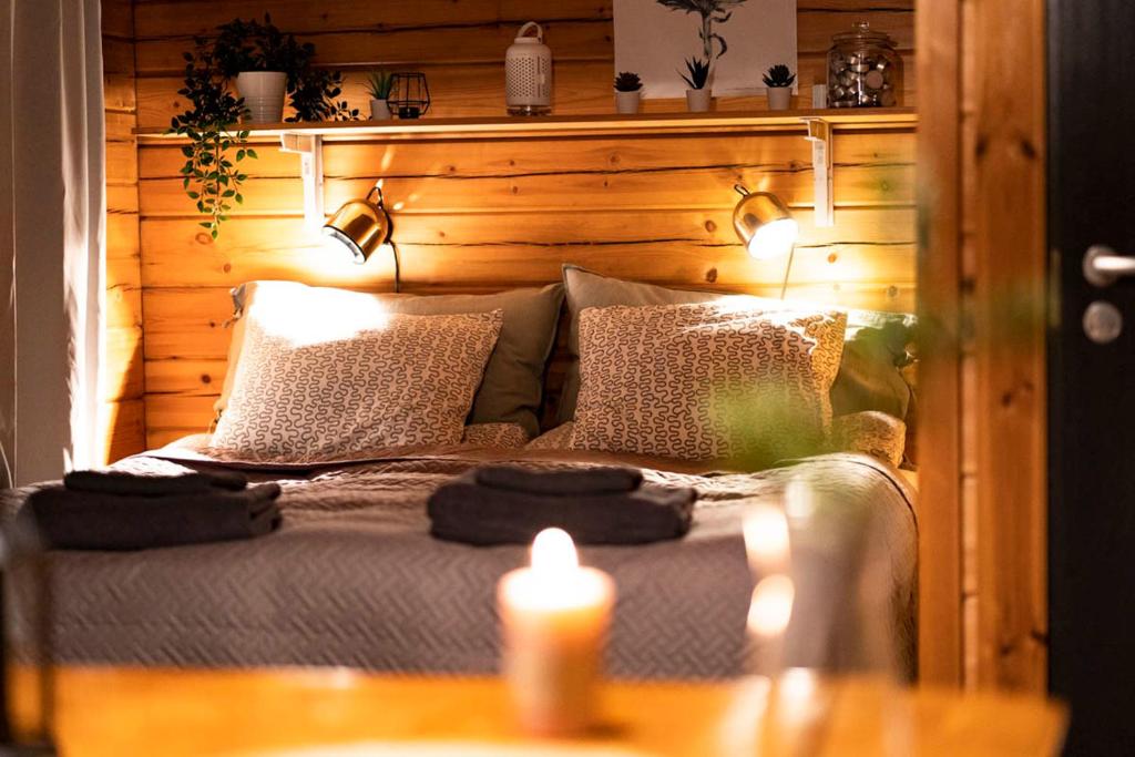 Un dormitorio con una cama con dos velas. en Cottage by the sea, en Hanko