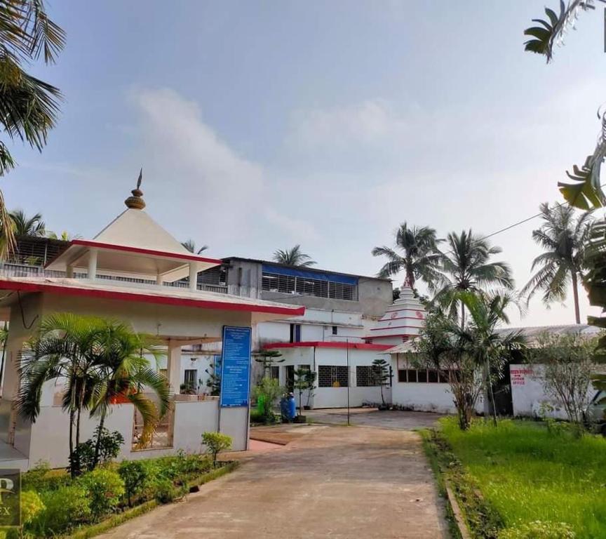 a building with palm trees in front of it at KRIYA YOGA RETREAT CENTER GANGASAGAR in Dublāt