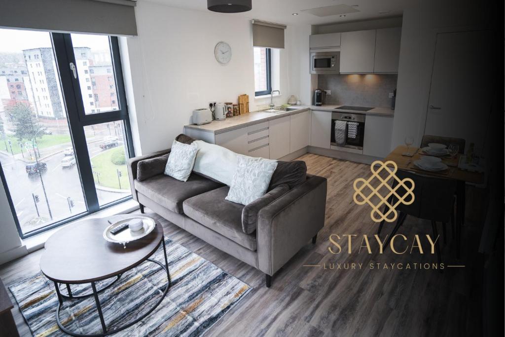 a living room with a couch and a table and a kitchen at Kelham Gate 1-Bed Apartments - City Centre - New - FREE Wi-Fi in Sheffield