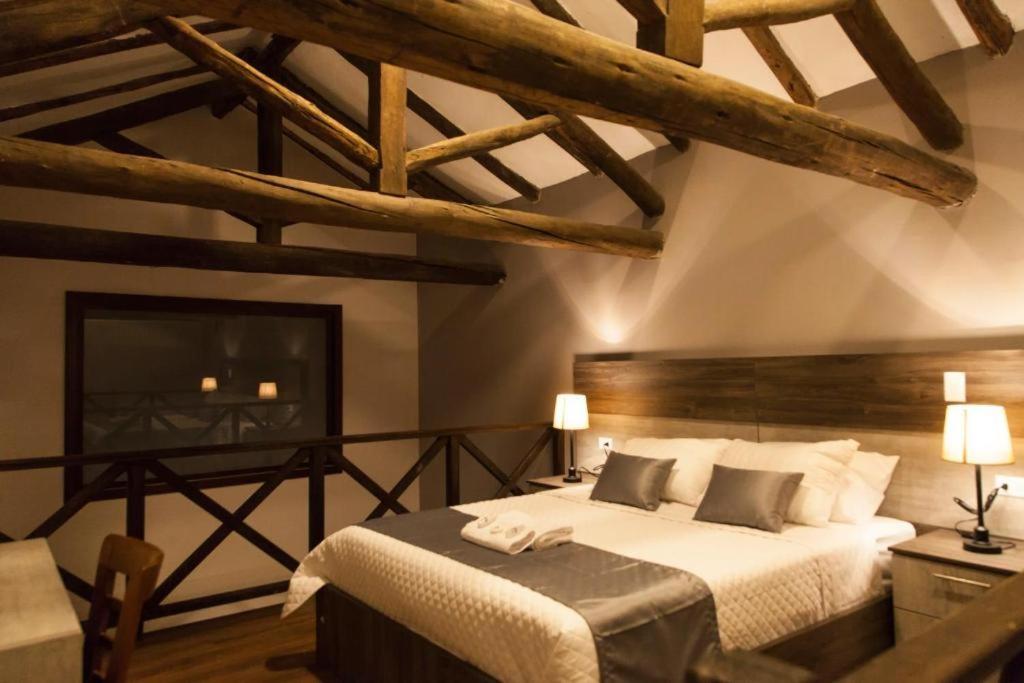 a bedroom with a large bed in a room with wooden ceilings at Hotel Raymipampa in Cuenca