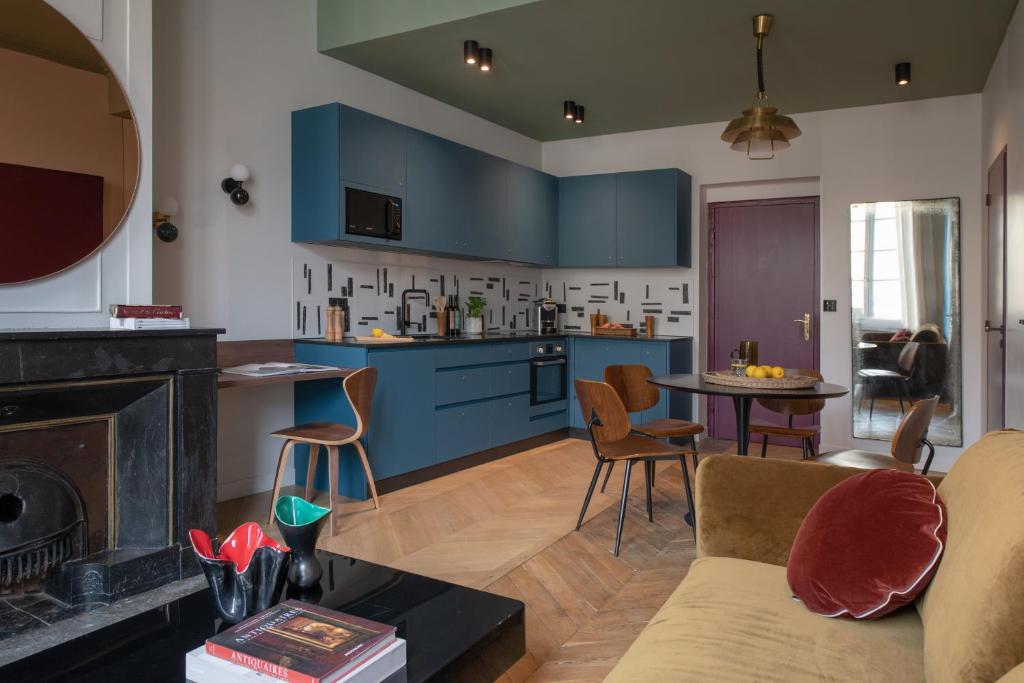 a living room with blue cabinets and a kitchen at MiHotel Blandan in Lyon