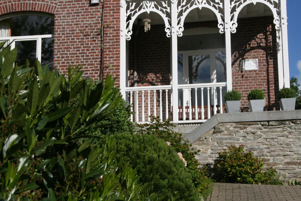 a porch of a brick house with a white gate at L'Hermine in Spa