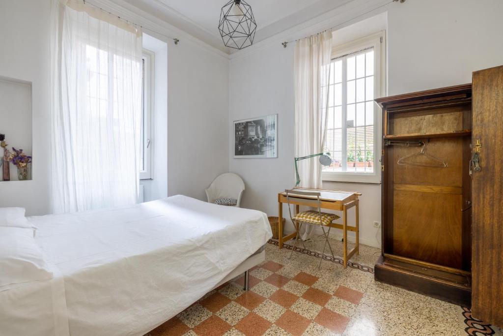 sypialnia z łóżkiem, biurkiem i oknami w obiekcie HospitalityRome Comfortable Apartament with Terrace w Rzymie