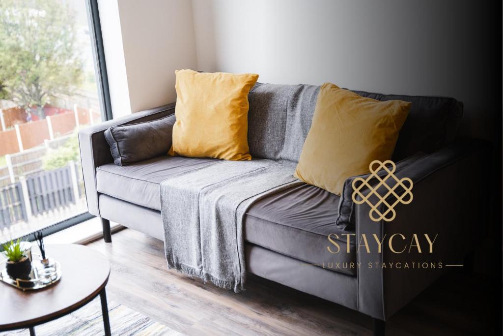 un sofá gris con almohadas amarillas en la sala de estar en The Interchange - 2-Beds - Brand New - Central, en Mánchester