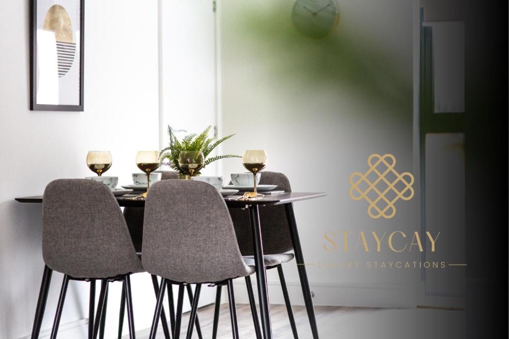 uma mesa de jantar com 3 cadeiras e copos de vinho em Modern 1-Bed Apartment - City Centre - FREE Wi-Fi - New - em Manchester
