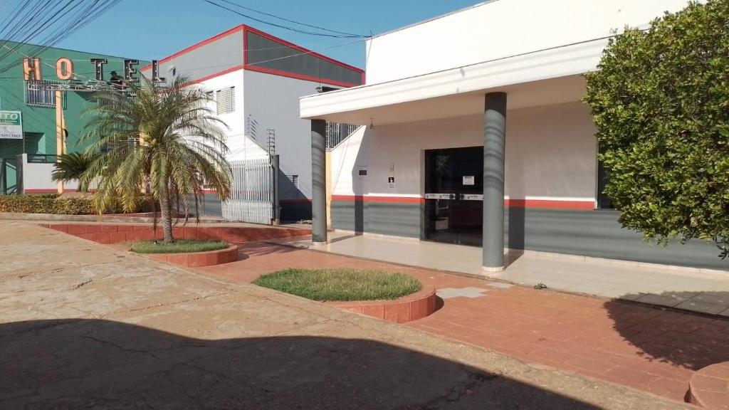um edifício com uma palmeira em frente em Astro Hotel em Rondonópolis