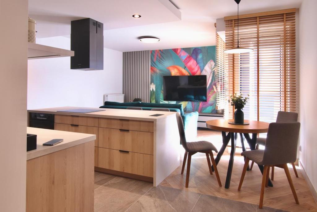 uma cozinha e sala de jantar com mesa e cadeiras em 5-star apartment em Gliwice