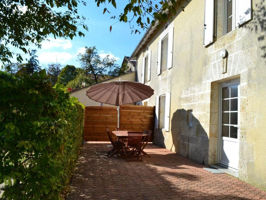 a table and chairs with an umbrella on a patio at Gîte typique Sud Charente, 2 chambres, terrasse, animaux acceptés, proche circuits randonnées - FR-1-653-78 in Salles-Lavalette