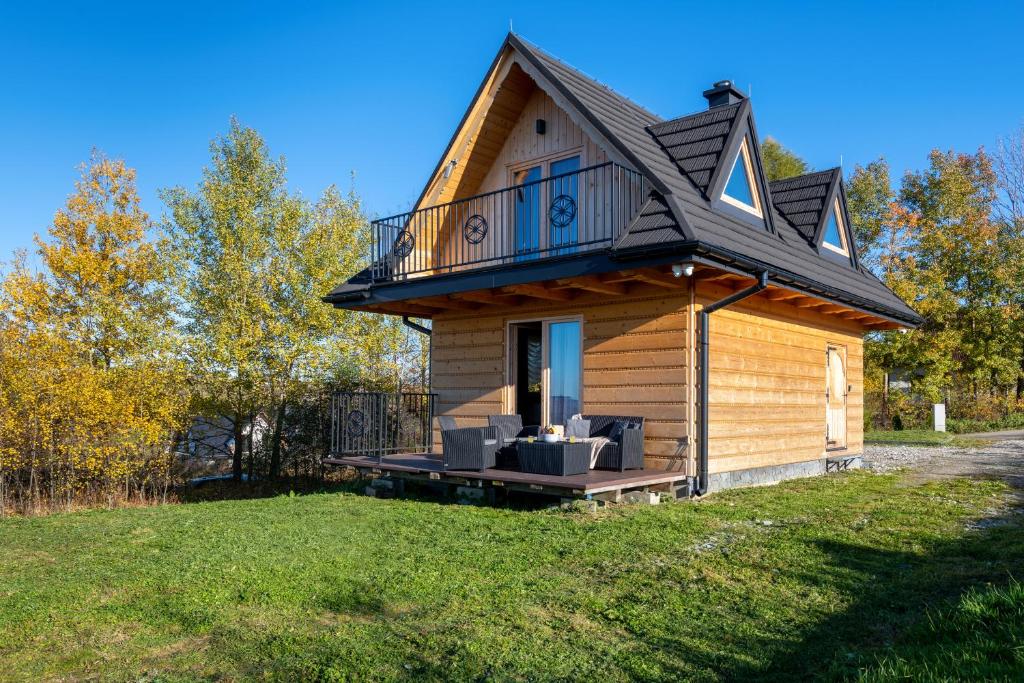 a tiny house with a porch and a balcony at TATRAHOLIDAY- Domek na wierchu in Szaflary