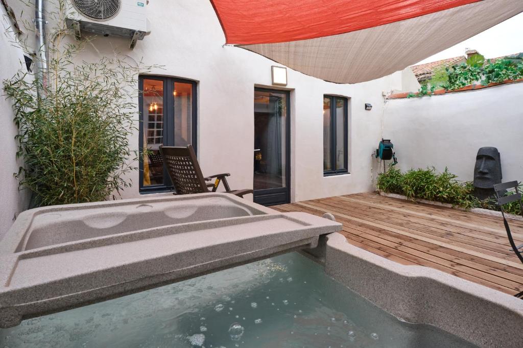 une maison avec un bassin profond sur une terrasse en bois dans l'établissement Melina - jacuzzi - maison avec cour climatisée proche cité médiéval, à Carcassonne