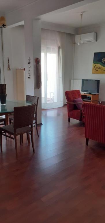 sala de estar con mesa, sillas y sofá en Cozy Penthouse, en Tesalónica